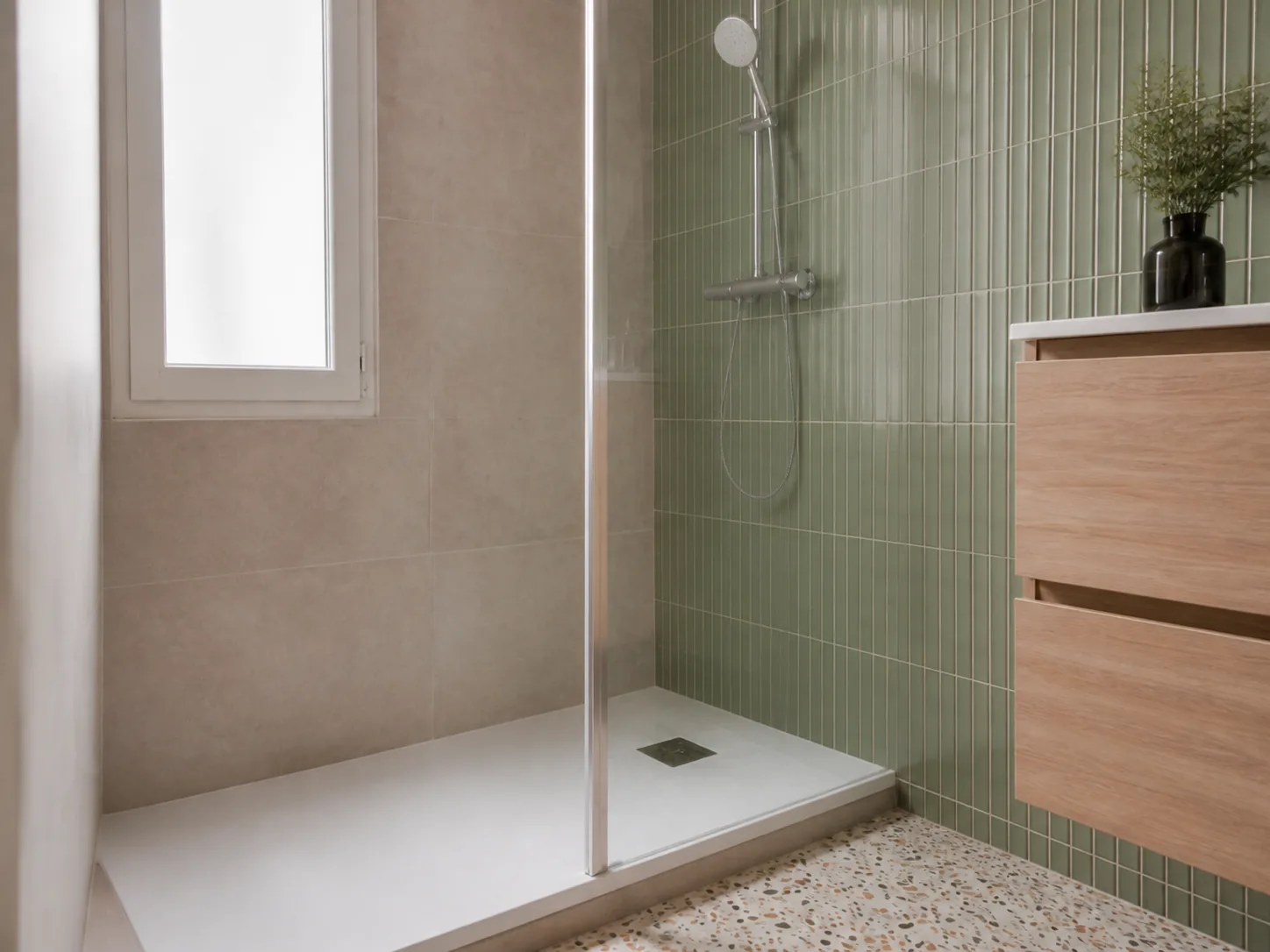 Image générée : détail du receveur de douche, de la paroi vitrée et du carrelage.