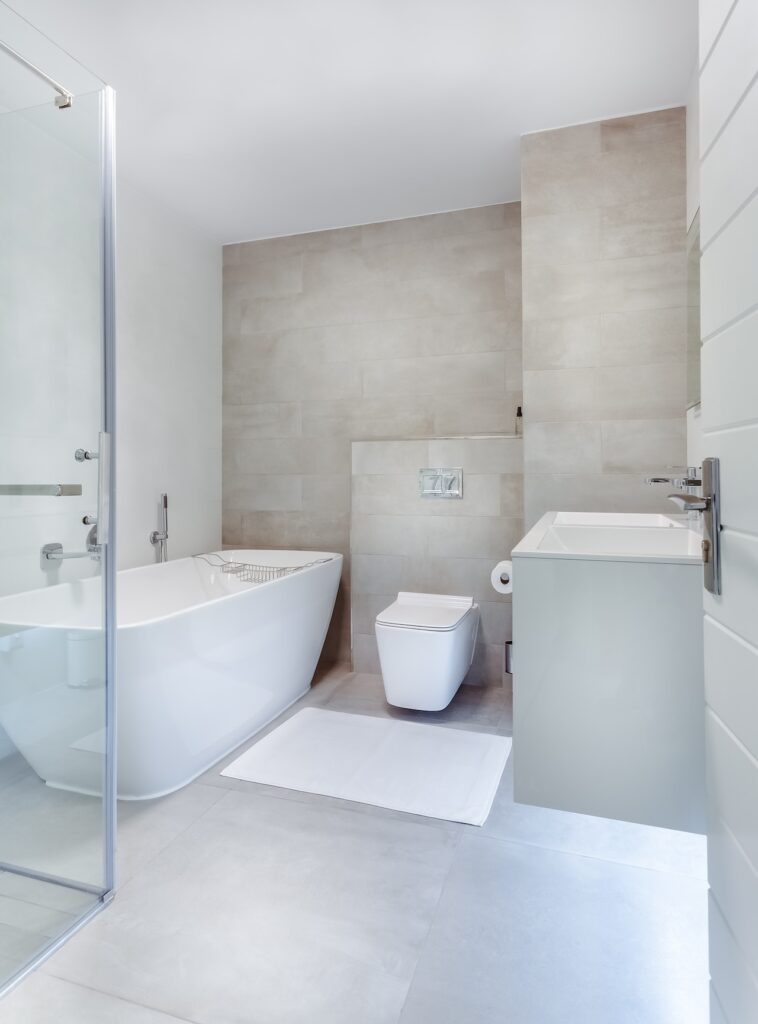 Salle de bains lumineuse avec baignoire et meuble vasque